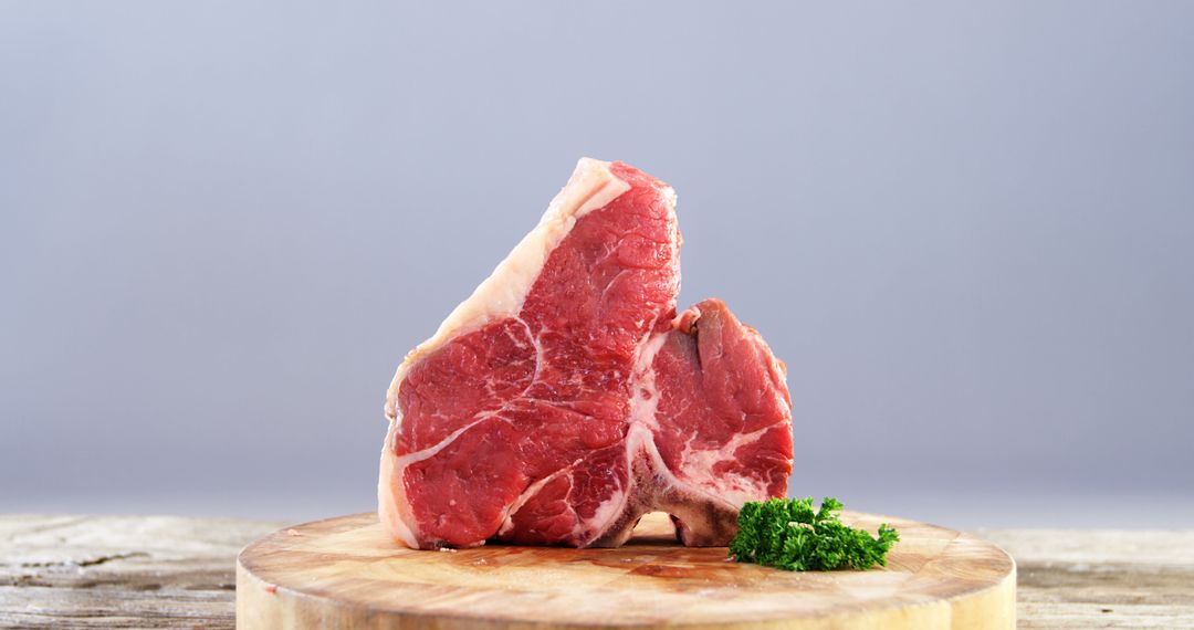 Raw T-Bone Steak on Wooden Cutting Board with Fresh Parsley - Free Images, Stock Photos and Pictures on Pikwizard.com