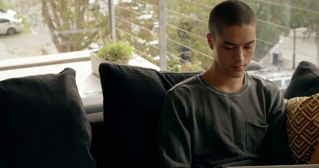 Teen Comfortably Working on Laptop at Home - Free Images, Stock Photos and Pictures on Pikwizard.com