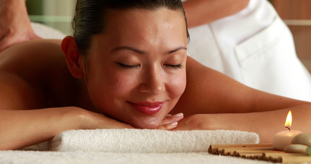 Woman Relaxing During Spa Massage with Lit Candle Nearby - Free Images, Stock Photos and Pictures on Pikwizard.com