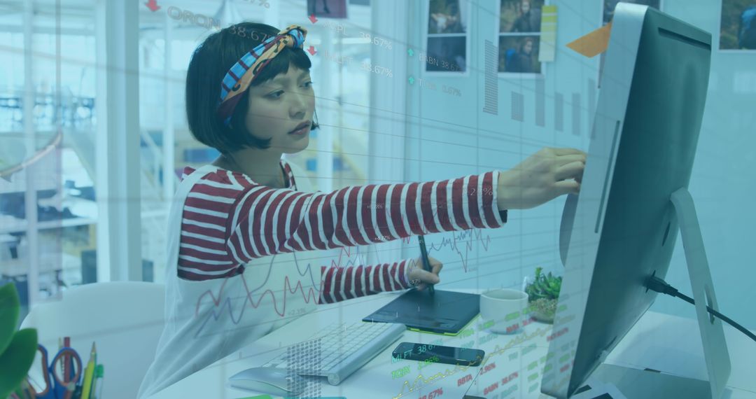 Asian Businesswoman Analyzing Financial Data on Computer Interface