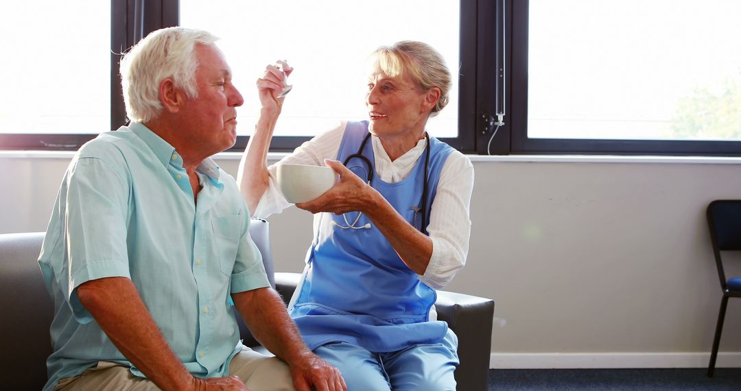 Nurse Feeding Elderly Man in Medical Facility - Free Images, Stock Photos and Pictures on Pikwizard.com