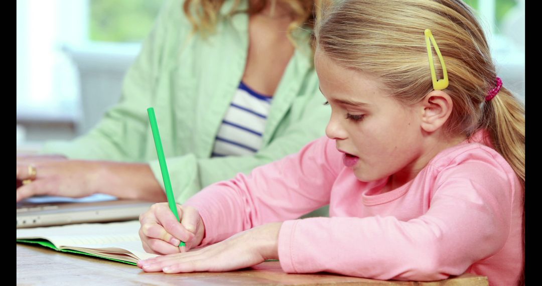 Young Girl Writing While Sitting at Table with Adult - Free Images, Stock Photos and Pictures on Pikwizard.com