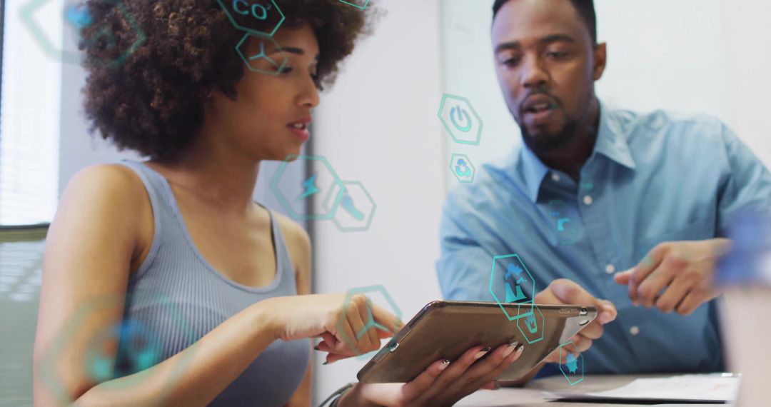 Diverse team collaborating on tablet with futuristic hexagon interface in modern office