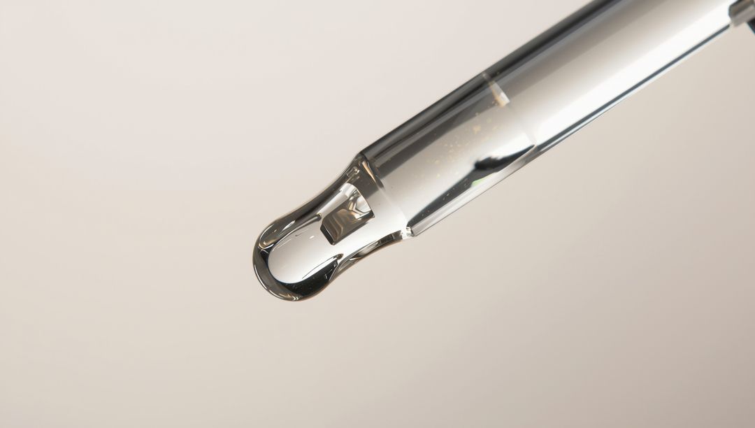 Close-up of Glass Dropper Pipette with Clear Liquid Droplet