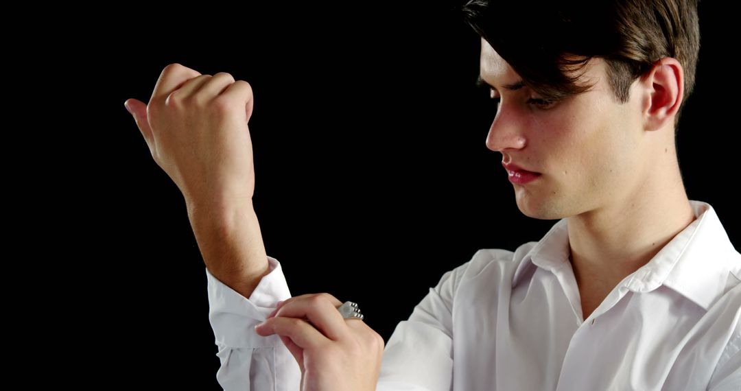 Handsome Young Man Adjusting Cuff of White Shirt - Free Images, Stock Photos and Pictures on Pikwizard.com