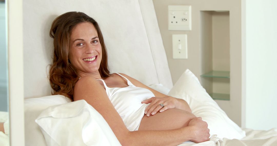 Smiling caucasian pregnant woman holding her belly at home, copy space - Free Images, Stock Photos and Pictures on Pikwizard.com