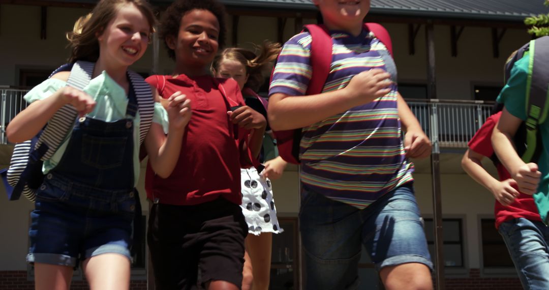 Joyful Children Running from School Building After Class