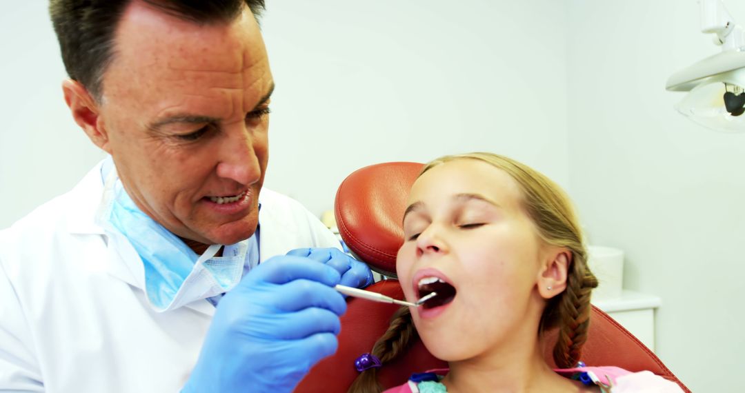 Dentist Examining Young Girl's Teeth in Dental Clinic - Free Images, Stock Photos and Pictures on Pikwizard.com