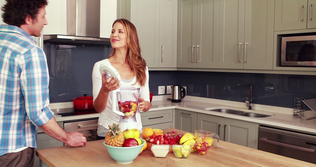 Joyful Couple Preparing Smoothie Together in Modern Kitchen