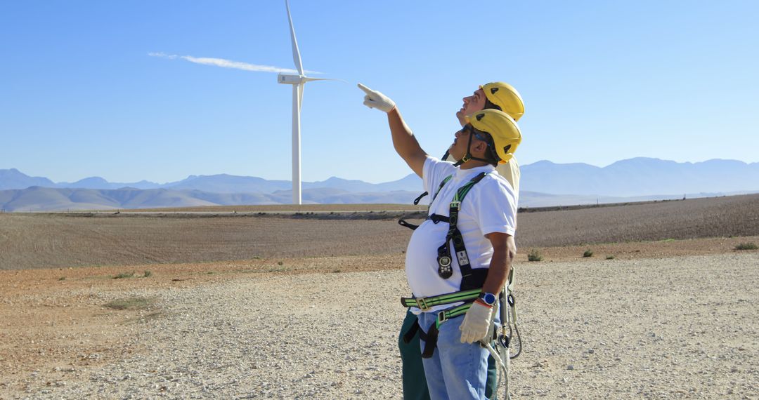 Engineers inspecting wind turbine in desert landscape - Free Images, Stock Photos and Pictures on Pikwizard.com