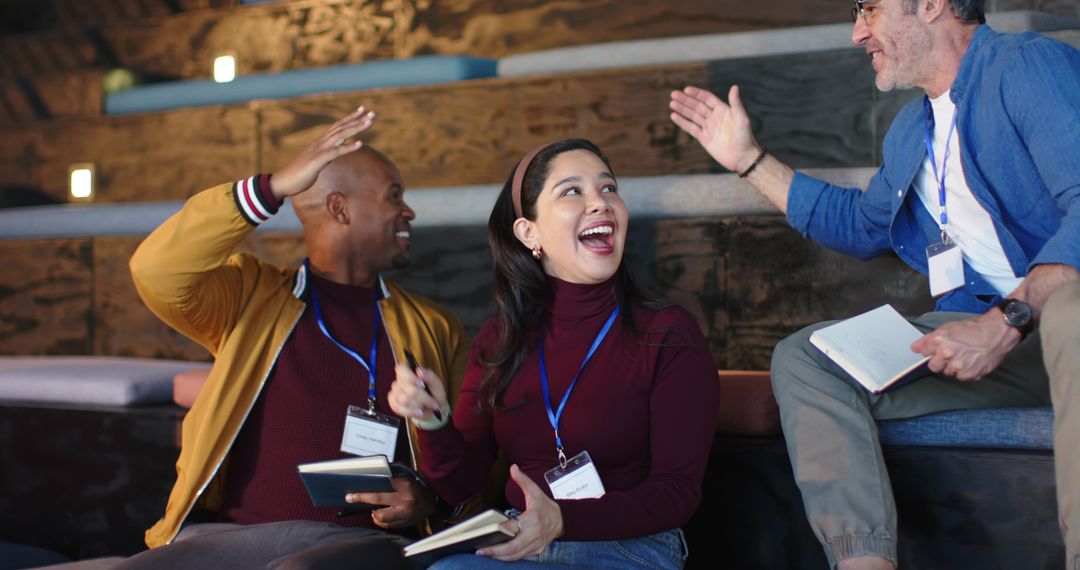 Multicultural team laughing, high-fiving and taking notes during interactive workshop