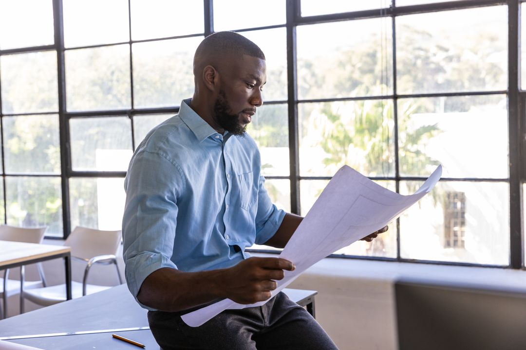 Confident Architect Analyzing Blueprints in Modern Design Office