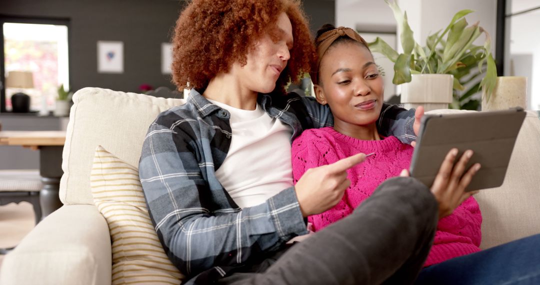 Diverse Couple Relaxing with Tablet on Stylish Couch