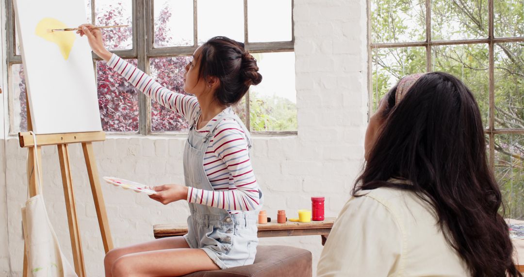 Art Student Learning Under Guidance of Mentor in Sunlit Studio
