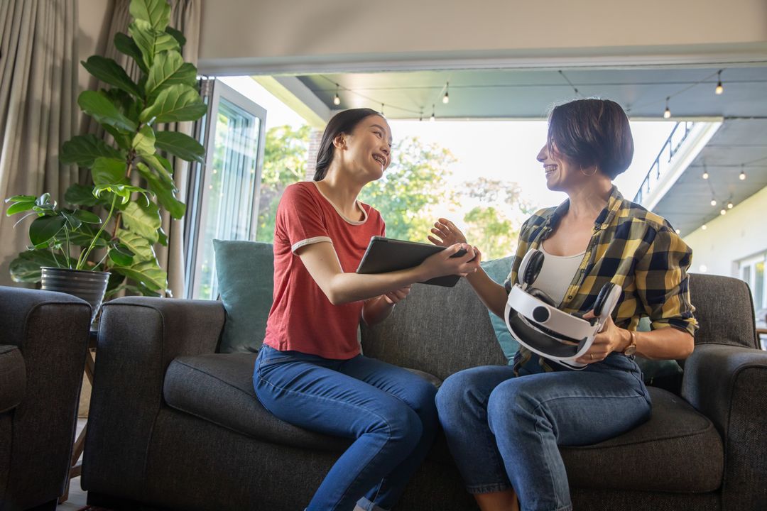 Mother and Daughter Explore Modern Tech with Tablet and VR Headset
