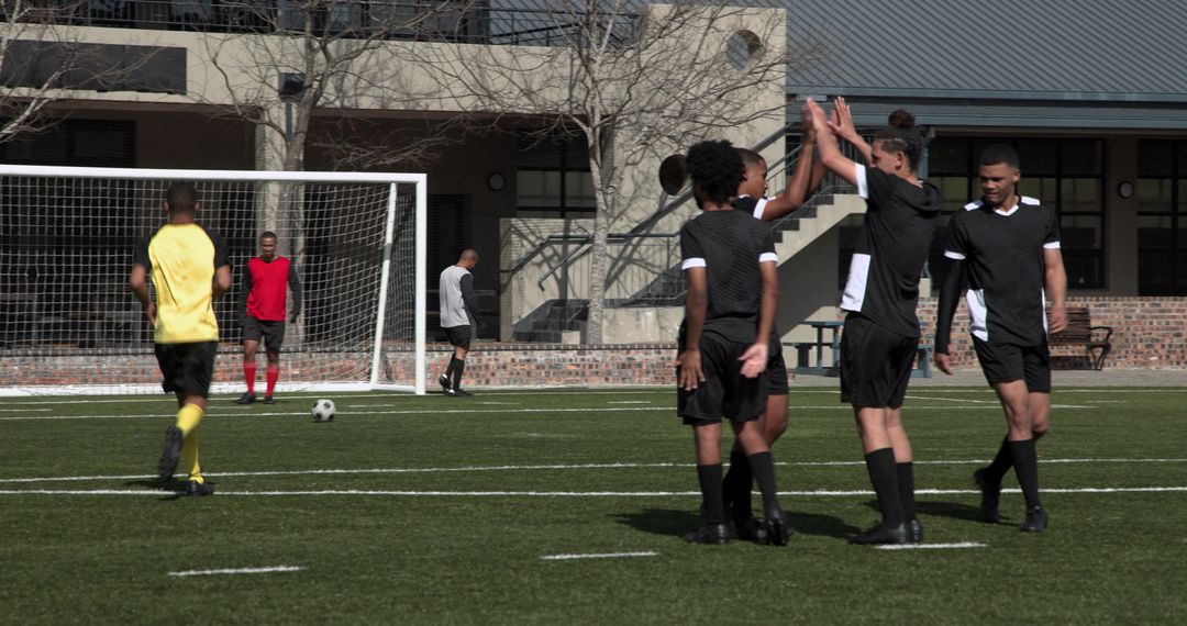 Soccer Players Strategizing on Green Turf during Match