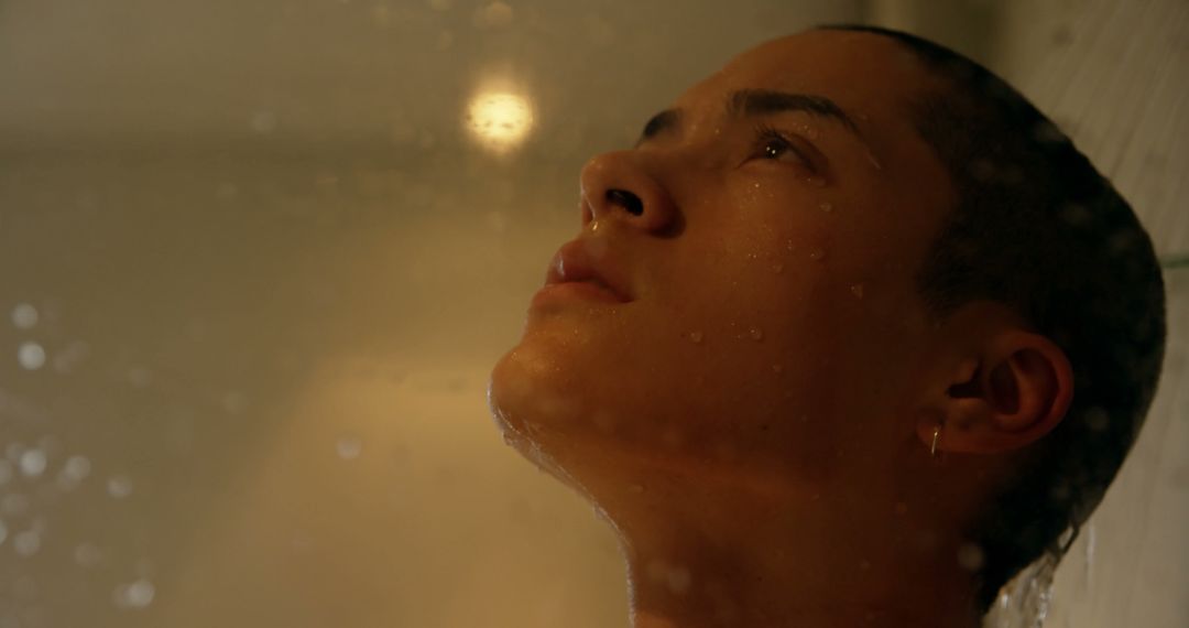 Introspective Young Person Standing in Shower with Water Droplets - Free Images, Stock Photos and Pictures on Pikwizard.com