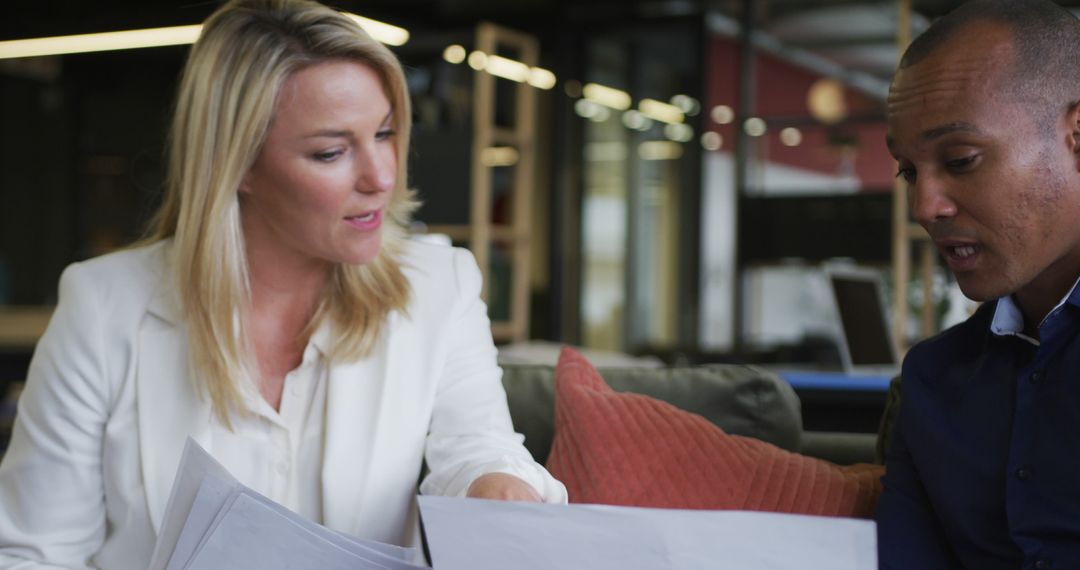 Colleagues Collaborating With Documents in Modern Office