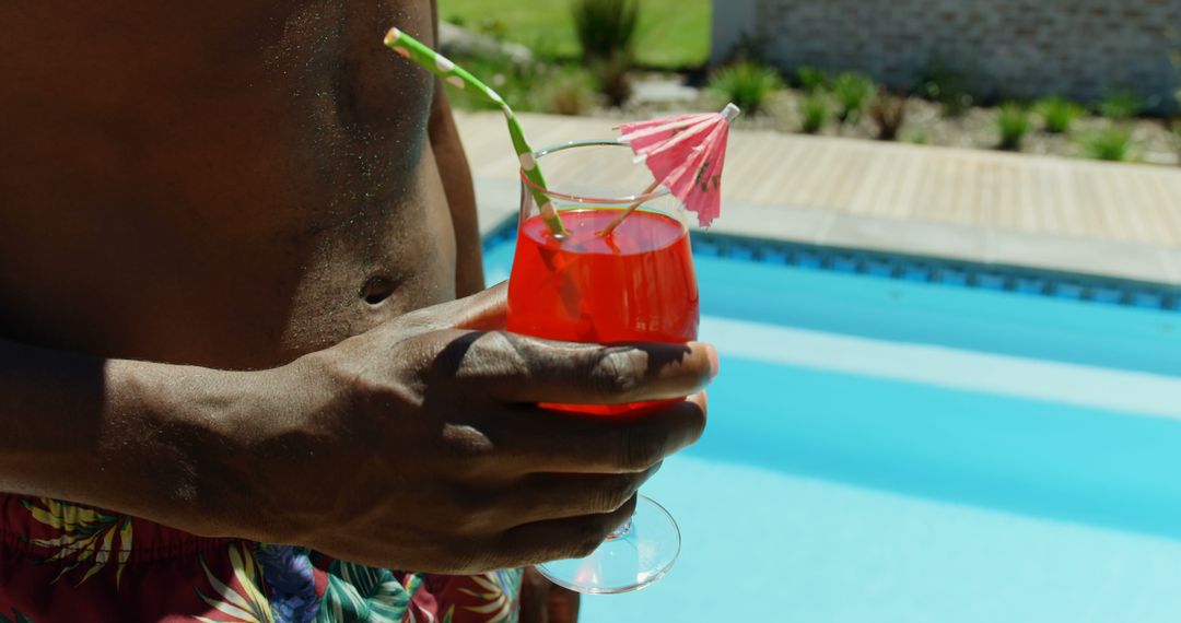 Man Holding Refreshing Cocktail by a Riverside Pool - Free Images, Stock Photos and Pictures on Pikwizard.com