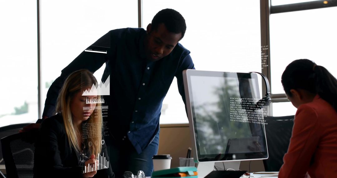 Collaborating team analyzing digital graphs and mobile data at modern office desk