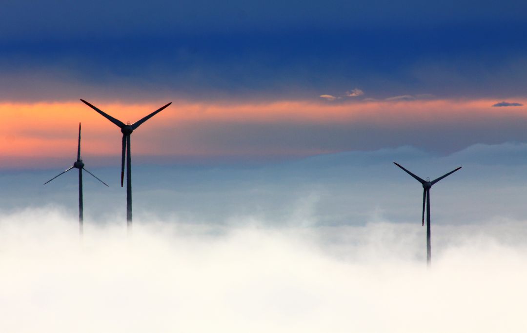 Wind Turbines Emerging Through Mist at Sunset - Free Images, Stock Photos and Pictures on Pikwizard.com