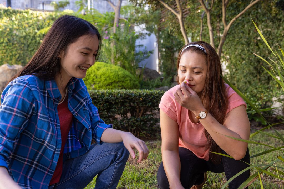 Mother and Daughter Bonding While Gardening in Tranquil Greenery