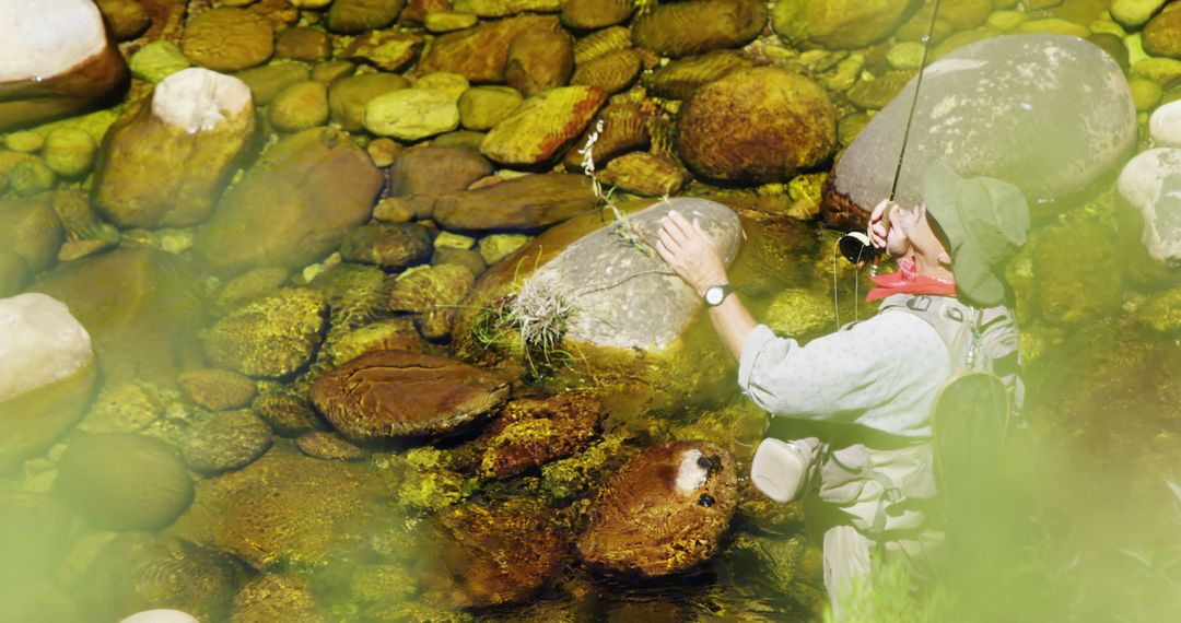 Man Fly Fishing in Clear Shallow Stream Surrounded by Rocks - Free Images, Stock Photos and Pictures on Pikwizard.com