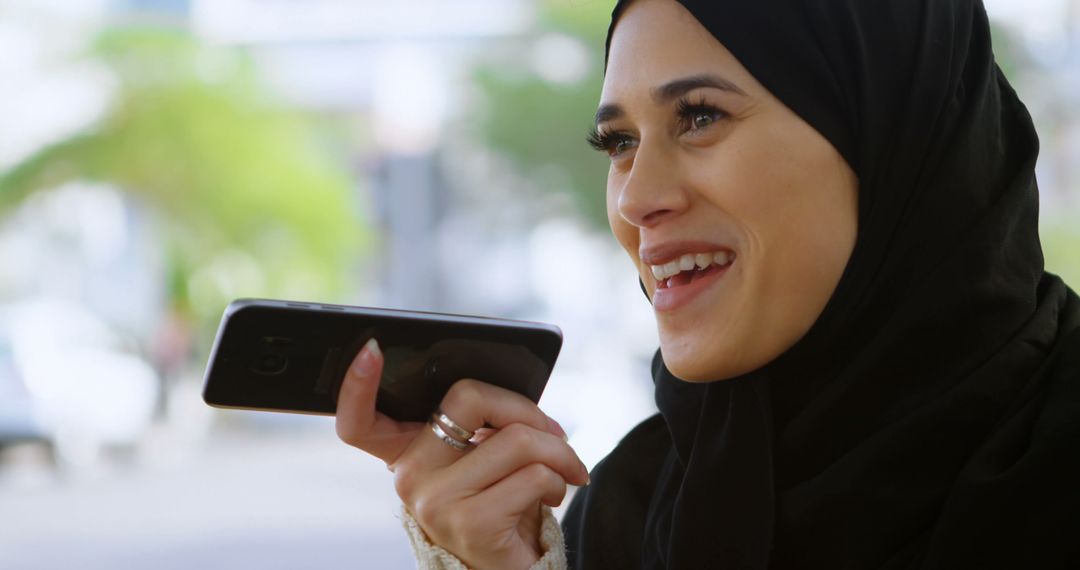 Smiling Arab Woman Communicating on Smartphone Outdoors - Free Images, Stock Photos and Pictures on Pikwizard.com