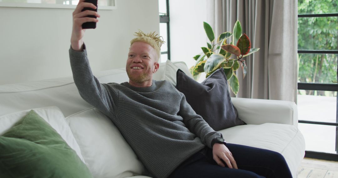 Cheerful Albino Man Taking Selfie on Smartphone at Home - Free Images, Stock Photos and Pictures on Pikwizard.com