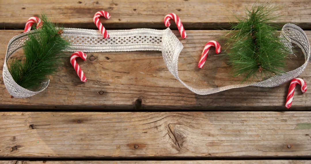 A rustic wooden backdrop features candy canes and pine for a traditional Christmas display. - Free Images, Stock Photos and Pictures on Pikwizard.com