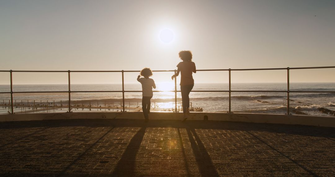 Mother and Child Watching Sunset by Ocean - Free Images, Stock Photos and Pictures on Pikwizard.com