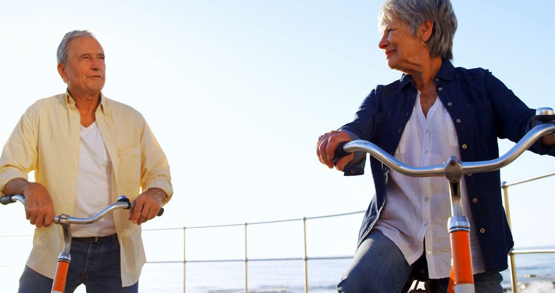 Senior Couple Riding Bicycles on Sunny Day Near the Ocean - Free Images, Stock Photos and Pictures on Pikwizard.com