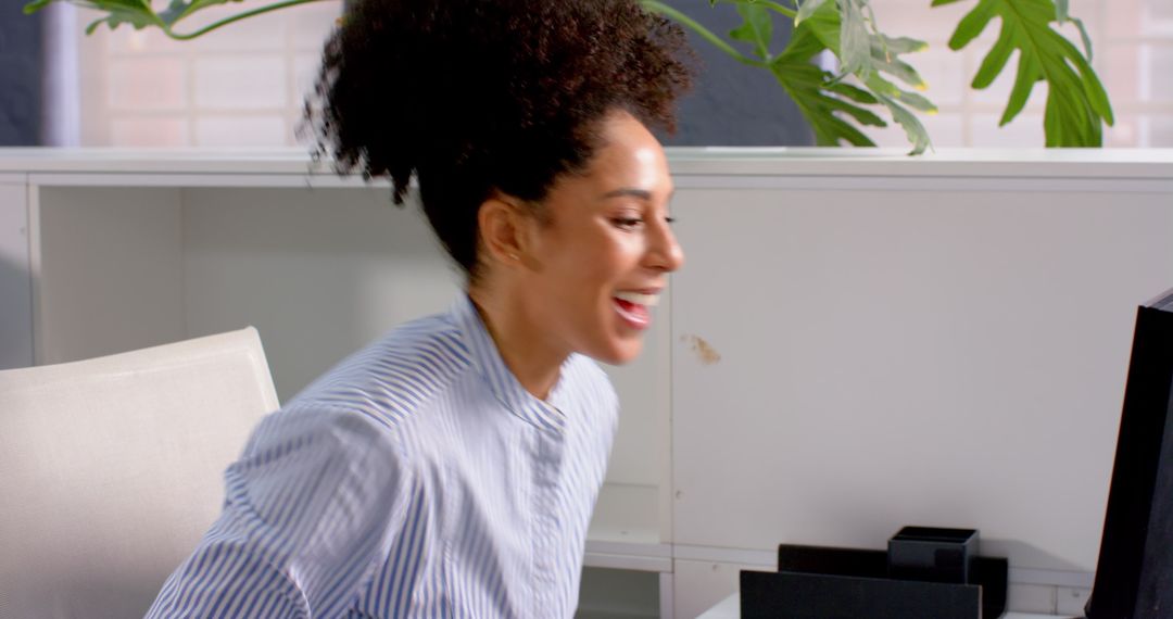 Excited African American Woman Celebrating Success at Office Desk