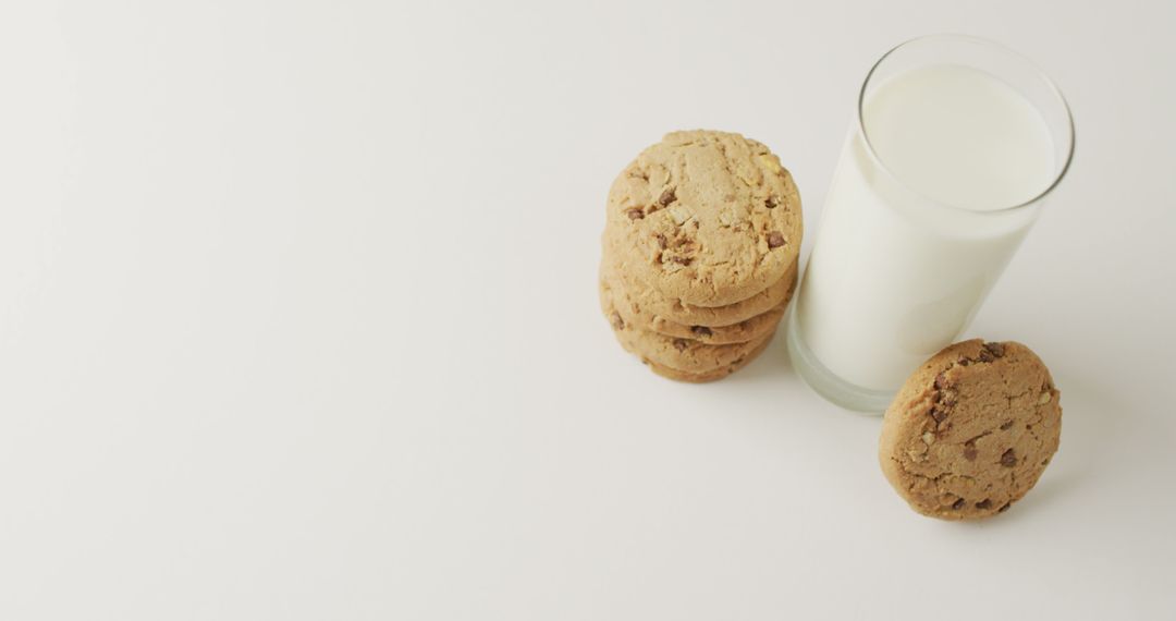 Stack of Chocolate Chip Cookies Next to Glass of Milk on White Background - Free Images, Stock Photos and Pictures on Pikwizard.com