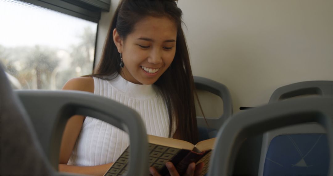 Young Woman Reading a Book on Public Transportation - Free Images, Stock Photos and Pictures on Pikwizard.com