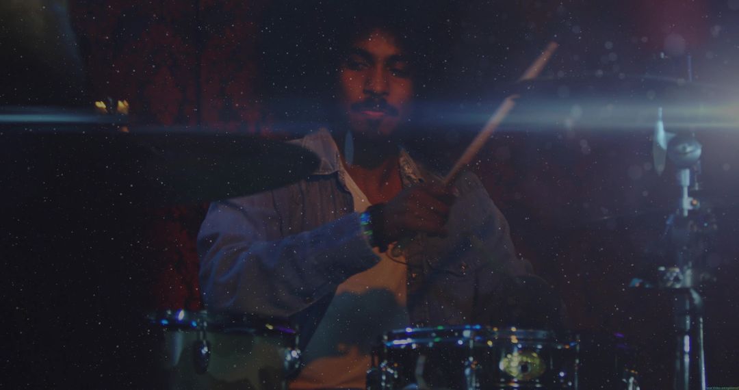 Drummer Playing on Dimly Lit Stage with Atmospheric Lighting