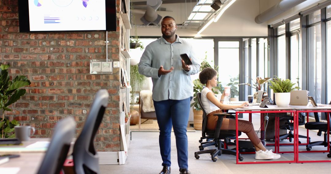 Confident Businessman Using Smartphone in Collaborative Workspace