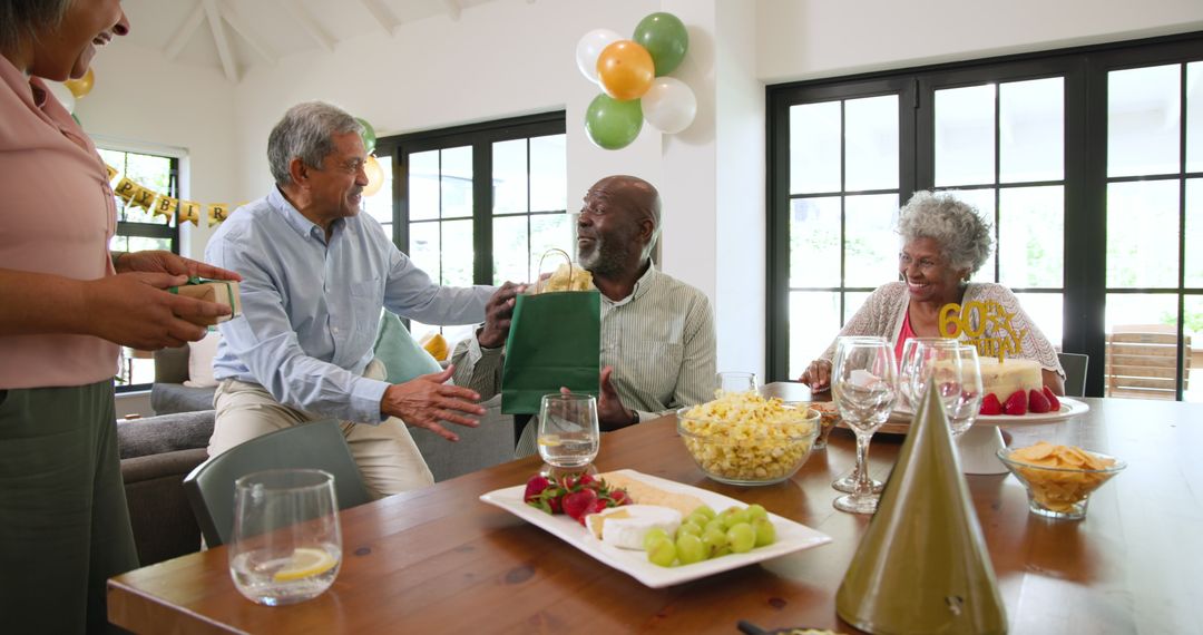 Joyful senior friends celebrating birthday with gift exchange