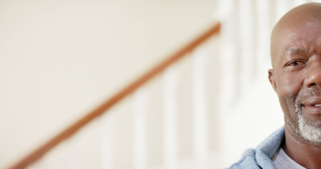 Closeup of African American Man Smiling by Staircase at Home - Free Images, Stock Photos and Pictures on Pikwizard.com