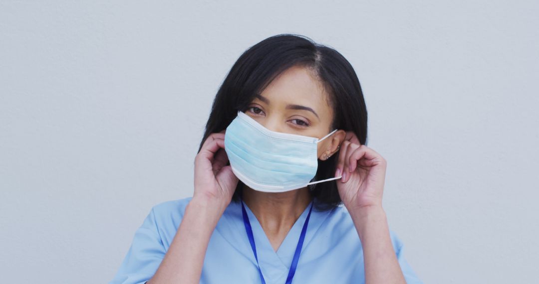 Healthcare Worker Putting on Face Mask - Free Images, Stock Photos and Pictures on Pikwizard.com