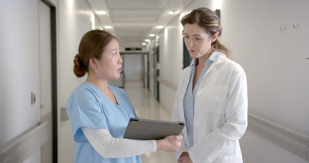 Medical Professionals Discussing Patient Care in Hospital Hall - Free Images, Stock Photos and Pictures on Pikwizard.com