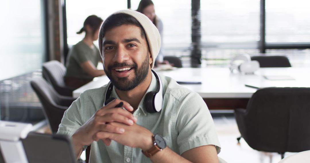 Smiling Young Professional with Tablet in Modern Workspace