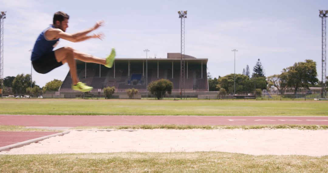 Athlete Jumping into Sand Pit during Long Jump - Free Images, Stock Photos and Pictures on Pikwizard.com