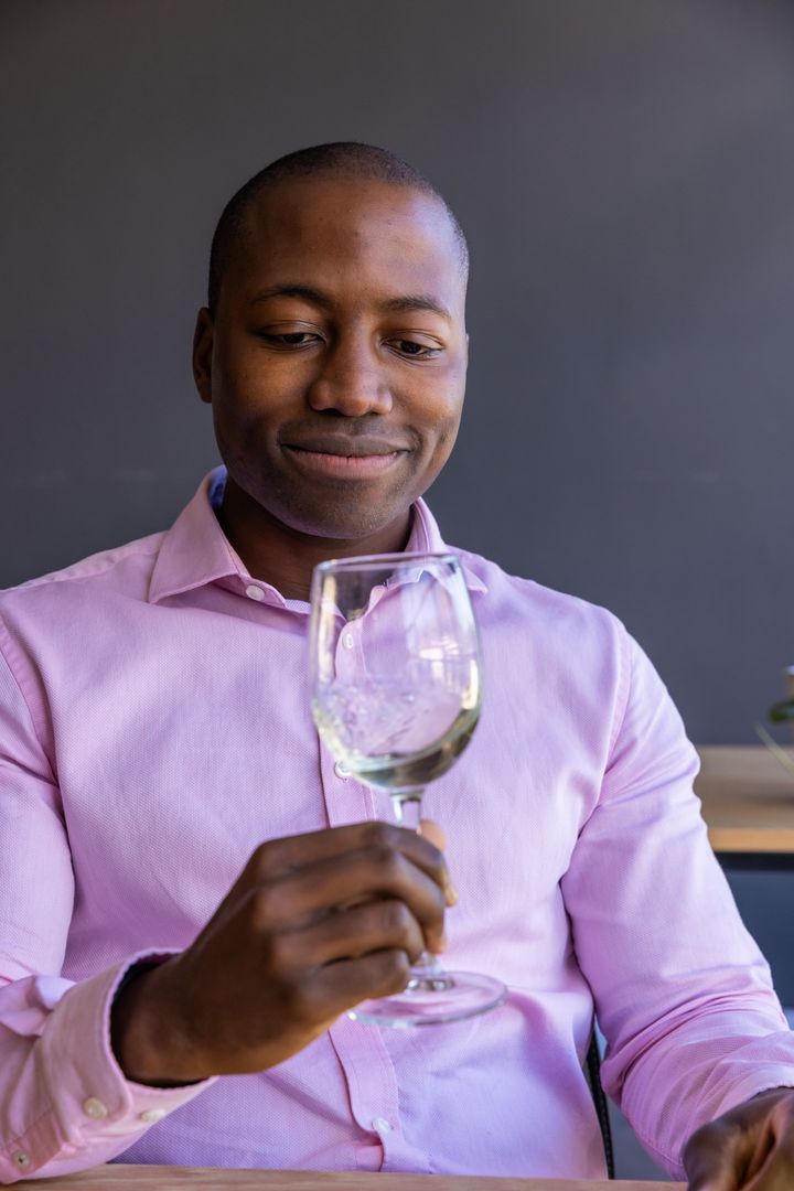 Man Contemplating Ice in Wine Glass at Modern Workspace