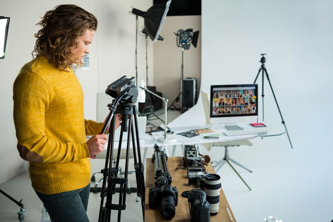 Photographer Adjusting Camera Tripod in Professional Studio