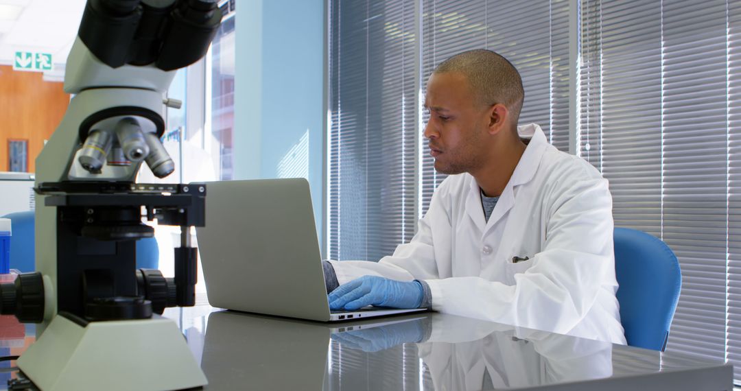 Scientist Working on Laptop Near Microscope in Lab - Free Images, Stock Photos and Pictures on Pikwizard.com