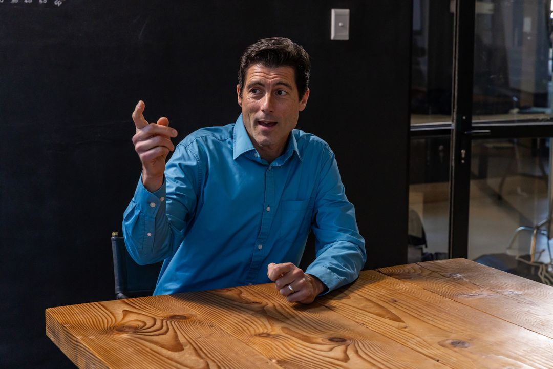 Middle-Aged Executive in Meeting Room Pointing at Board