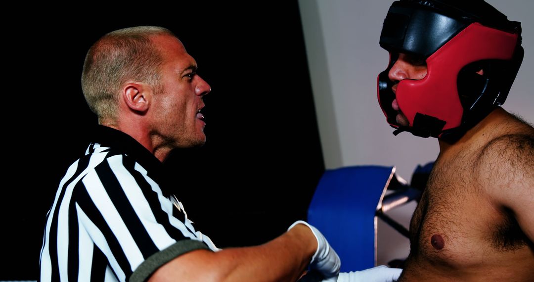 Boxing referee intensely instructing fighter in match - Free Images, Stock Photos and Pictures on Pikwizard.com