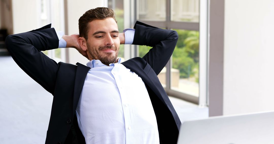 Smiling Businessman Relaxing While Working on Laptop in Office - Free Images, Stock Photos and Pictures on Pikwizard.com