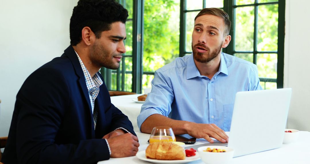 Two businessmen discussing ideas during breakfast meeting - Free Images, Stock Photos and Pictures on Pikwizard.com